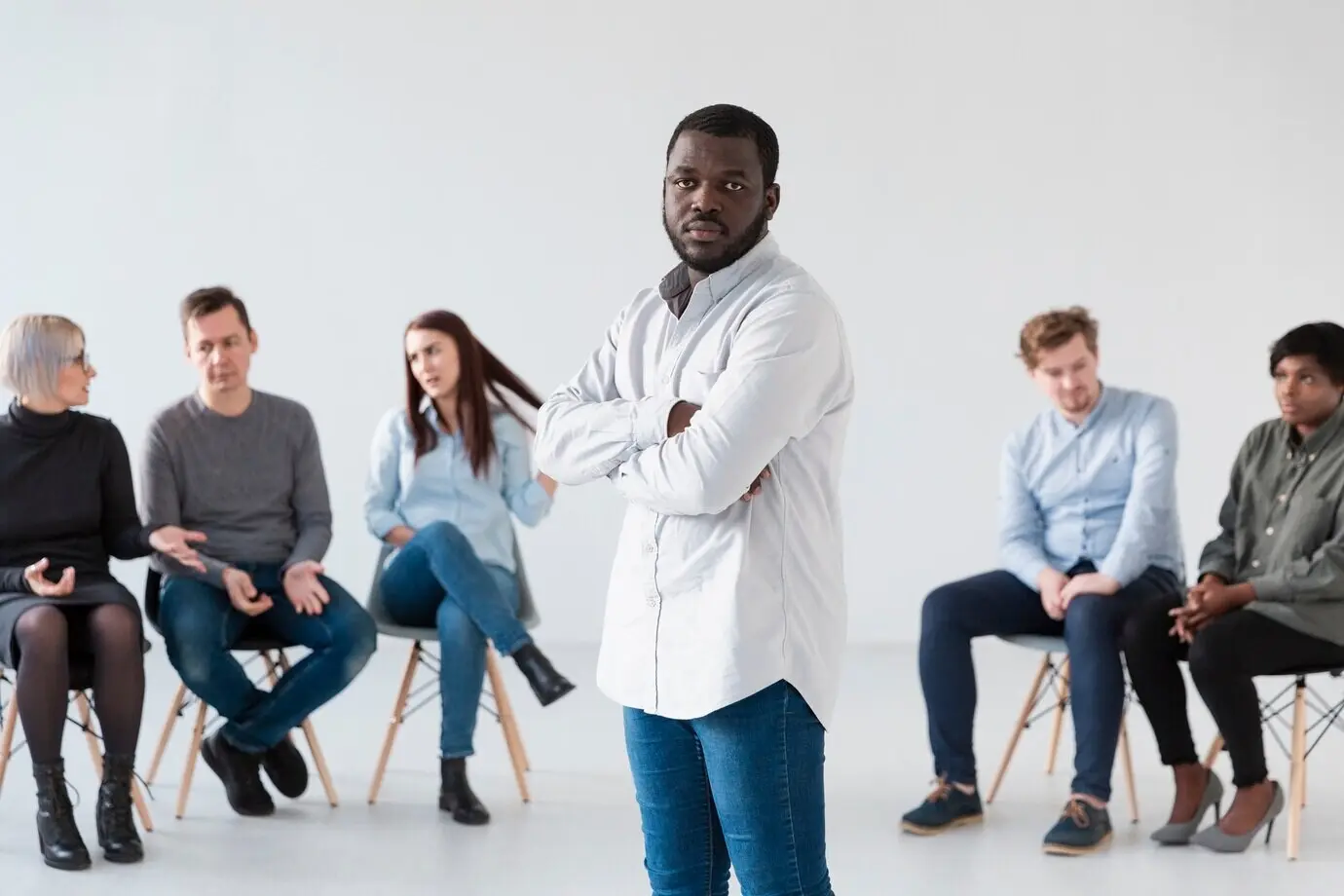 Upset rehabilitation patients stand with their hands crossed.